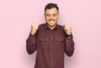 Sticker - Young hispanic man wearing casual clothes excited for success with arms raised and eyes closed celebrating victory smiling. winner concept.