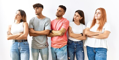 Sticker - Group of young friends standing together over isolated background looking to the side with arms crossed convinced and confident