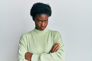 Poster - Young african american girl wearing casual clothes skeptic and nervous, disapproving expression on face with crossed arms. negative person.