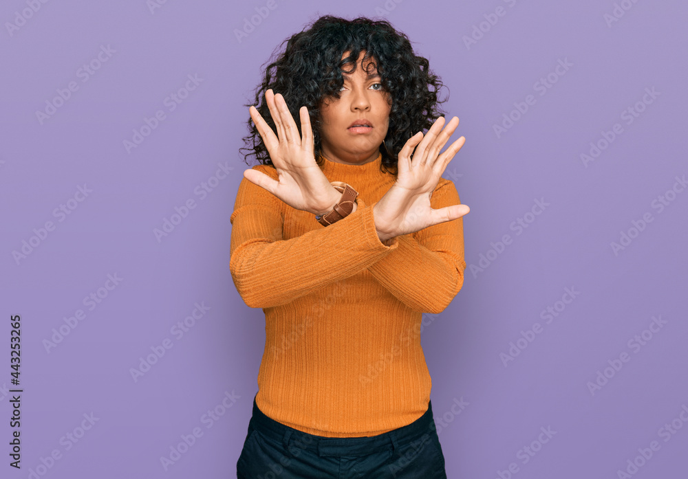 Young hispanic woman wearing casual clothes rejection expression crossing arms doing negative sign, angry face