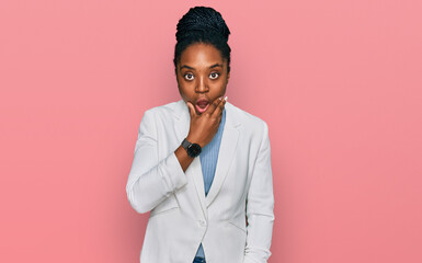 Wall Mural - Young african american woman wearing business clothes looking fascinated with disbelief, surprise and amazed expression with hands on chin