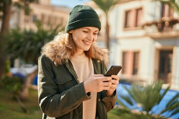 Canvas Print - Young caucasian girl smiling happy using smartphone at the city.