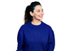 © Krakenimages.com - Young hispanic woman wearing casual clothes looking away to side with smile on face, natural expression. laughing confident.