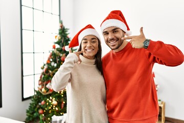 Sticker - Young hispanic couple standing by christmas tree smiling cheerful showing and pointing with fingers teeth and mouth. dental health concept.