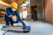 © tong2530 - Select focus floor tile cutting equipment, Asian artisan tiler at construction site, worker cuts a large slab of tile during the construction of a house