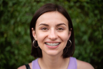 Young girl smiling with metal dental braces on teeth