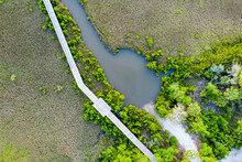 Aerial View Of Florida Wetlands And Wooden Walkway Over Marsh.
