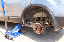 Сar At The Tire Mounting With Removed Wheel On Pneumatic Jack
