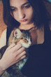 © natavilman - A beautiful girl holds a pet in her arms.