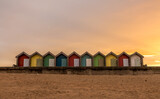 Fototapeta  - The vibrant and colorful beach huts by the promenade overlooking Blyth beach with a lovely sunset in Northumberland, England