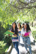 © FABIAN PONCE GARCIA - Selective focus of two teenage Latina friends happily going to high school with other friends behind them on a sunny morning