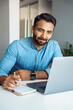 © Stock 4 You - Portrait of handsome young indian man student watching online webinar using laptop and earphone making noes in notebook. Video conference call, business training tutorial, coaching course concept