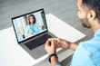 © Stock 4 You - View over male client shoulder sit at desk receive medical consultation online from female doctor. Indian man listening practitioner. Distant communication, health protection and telemedicine concept