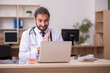 © Elnur - Young male doctor sitting in the office