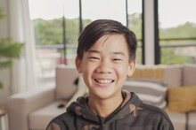 POV Portrait Of Happy Asian Preteen Teen Boy Smiling And Making Video Calling At Home, Using Zoom Online Virtual Class