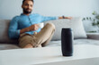 © Stock 4 You - Young man on sofa listening small portable wireless speaker at smart home