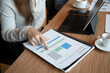 © Prathankarnpap - Cropped shot businesswoman reading report document at office desk.