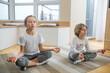 © zinkevych - Kids doing yoga together at home and sitting in meditation