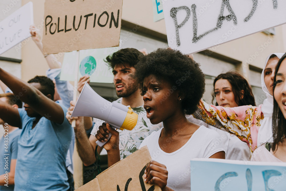Public demonstration on the street against global warming and pollution. Group of multiethnic people making protest about climate change and plastic problems in the oceans - obrazy, fototapety, plakaty 
