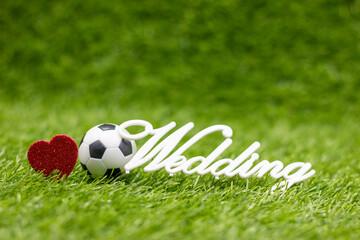 Soccer ball with wedding word on green grass 