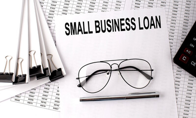 SMALL BUSINESS LOAN text on paper with chart and office tools , business concept