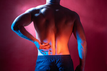 Back pain. Concept - person is tormented by problems with lower back. Man with a naked torso holds on to his side. Man with a sore lower back to camera. Pain in left side. Human health problems