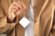 Keychain mockup to display design. Key chain mock up in woman hand. Blank rhombus white sublimation key chain photo.