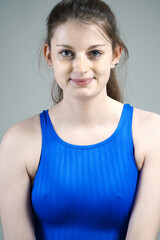 Wall Mural - Portrait of a beautiful young woman wearing blue swimsuit in studio	