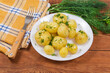 Serving of boiled young potatoes with dill on rustic table