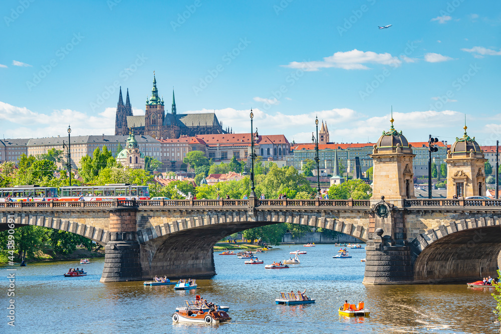 Panoramic view over magnificent Vltava river with Saint Vitus Cathedral near Charles Bridge and walking embarkment in historical downtown of Prague, Czech Republic. - obrazy, fototapety, plakaty 