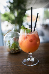 A glass of slushy cocktail in a beach bar