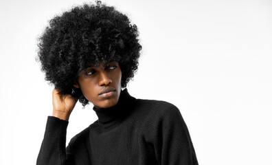 Wall Mural - Portrait of young handsome black man touching his afro hair isolated on white background