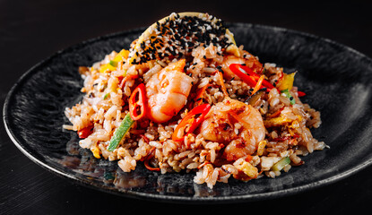 Wall Mural - Fried rice with shrimp and vegetables in plate on wooden table background