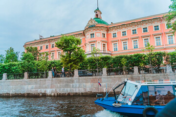 Wall Mural - Beautiful view of the Neva river canal in the city center with tourist excursion boats, postcard view. Saint Petersburg, Russia - 28 June 2021