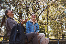 Two Women Laughing On Joke In Park