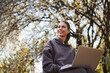 © Viacheslav Yakobchuk - Positive woman is working with laptop outdoors