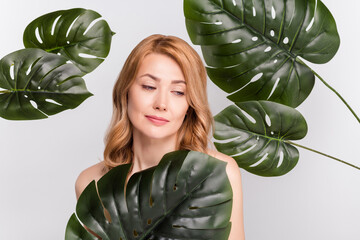 Poster - Portrait of attractive woman covering with pure green plant health care isolated over grey pastel color background