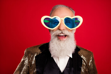 Poster - Portrait of attractive elderly cheerful grey-haired man wearing large specs isolated over bright red color background