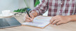 © EduLife Photos - Close-up businessman holding a pen, smartphone and pointing at financial graph checking business report on wooden desk with computer laptop besided at home. Stock photo