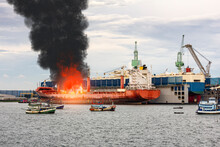 Large General Cargo Ship For Logistic Import Export Goods And Other The Explosion And Had A Lot Of Fire And Smoke While Moored At Harbor In Afternoon