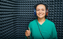 Portrait Adult Woman While Hearing Check-up At Soundproof Audiometric Cabin Using Audiometry Headphones And Audiometer