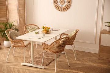 Wall Mural - Stylish white dining table and wicker chairs in room. Interior design