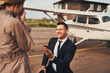 Cheerful man making proposal to his girlfriend at airdrome