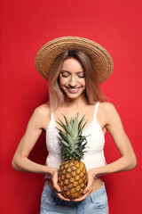 Sticker - Young woman with fresh pineapple on red background. Exotic fruit