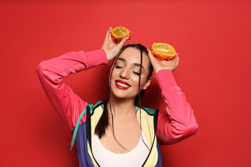 Wall Mural - Young woman with fresh kiwano on red background. Exotic fruit