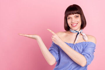 Sticker - Photo of cheerful young happy nice woman point finger hold hand empty space isolated on pink color background