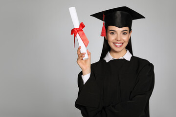 Wall Mural - Happy student with graduation hat and diploma on grey background. Space for text