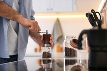 Man Using Manual Coffee Grinder In Kitchen, Closeup
