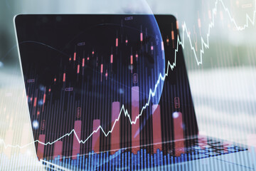 Abstract creative financial graph with world map on modern laptop background, forex and investment concept. Multiexposure