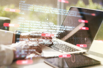 double exposure of abstract programming language hologram with hands typing on laptop on background,